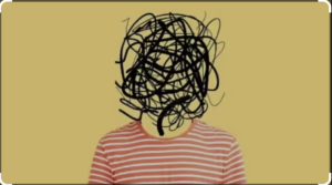 A person wearing an orange and white striped shirt with their face replaced by a scribble of black lines on a beige background.